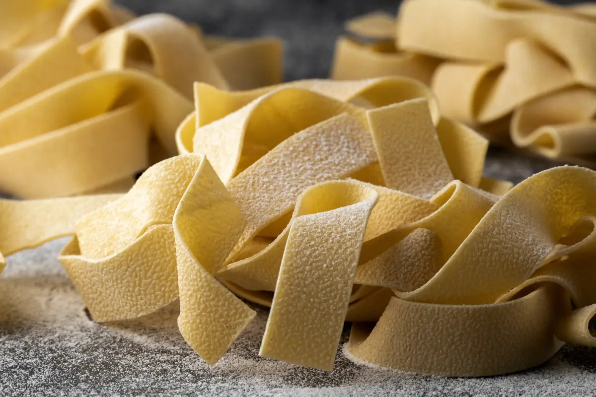 Fresh pappardelle pasta ribbons dusted with semolina flour